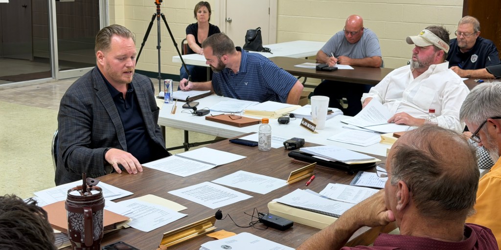 Jason Edwards (left), owner of Edwards Company Group, discusses his proposal to repair roofs on city-owned buildings during the Oct. 8 Glenwood City Council meeting. Photo by Michael Hibblen